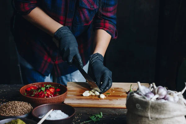 Donna mani in guanti neri taglio aglio — Foto Stock