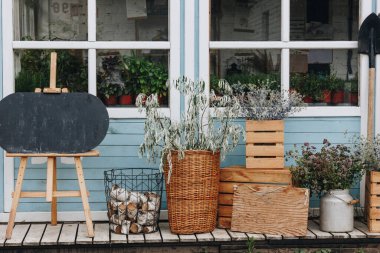 Ağaç evin önündeki vazoda kurumuş çiçekler.