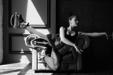 Kangoo atlayışı için ayakkabıyla poz veren güzel beyaz kadın koltukta oturuyor.