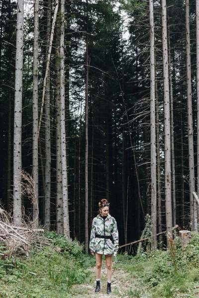 Karpatlar, Ukrayna 'da çam ormanlarının önünde duran kadın turist.