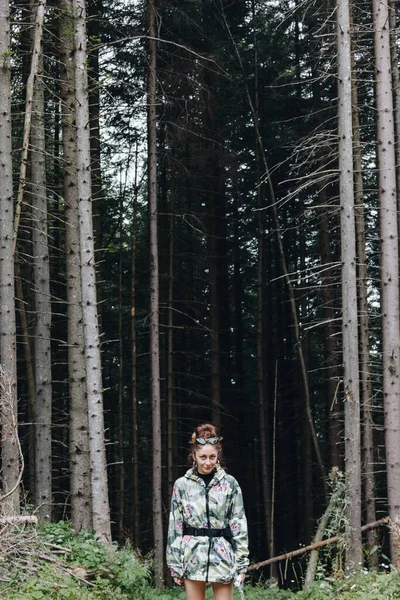 Karpatlar, Ukrayna 'da çam ormanlarının önünde duran kadın turist.