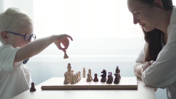 El niño jugando con su madre en el ajedrez — Vídeo de stock