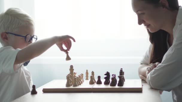 The boy playing with his mother in chess — Stock Video