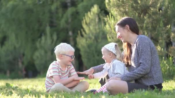 Mamma, son och dotter leker med en sten sax papper i parken — Stockvideo