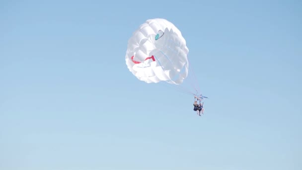 Два человека летают в небе на парашюте — стоковое видео