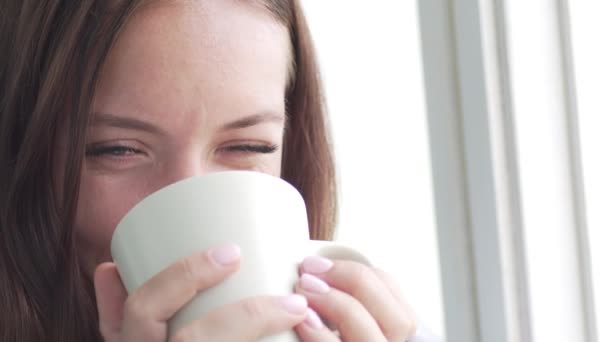 La chica está bebiendo té de una taza . — Vídeo de stock