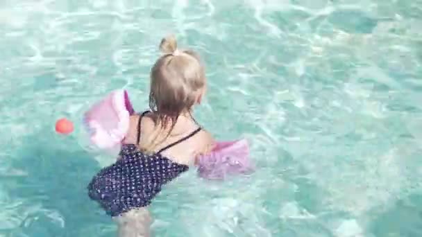 Niña está nadando en la piscina — Vídeo de stock