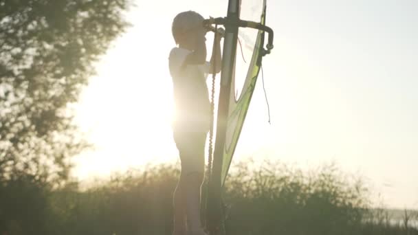 Malý chlapec se učí udržet rovnováhu na windsurf. — Stock video