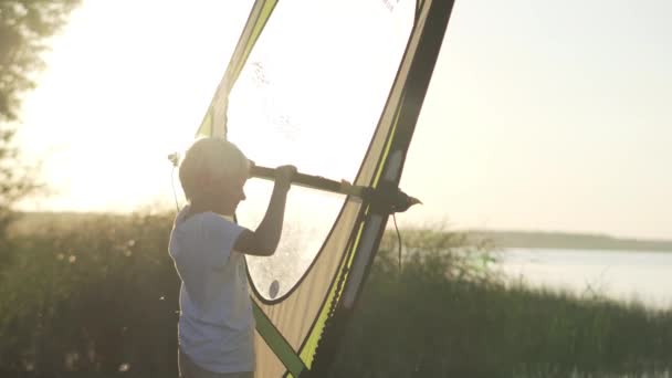 De jongen leert om te windsurfen. Opleiding op het land. — Stockvideo