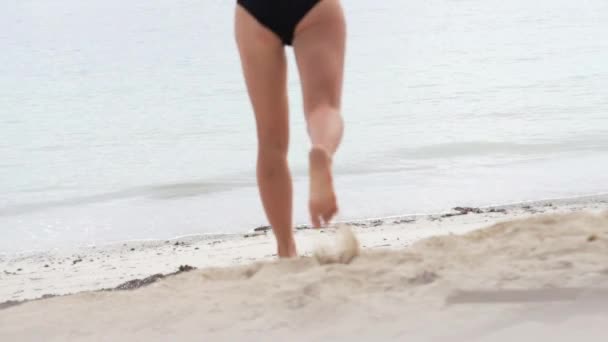 A girl in a swimsuit is running into the sea — Stock Video