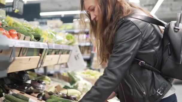 Flicka väljer grönsaker i snabbköpet. — Stockvideo