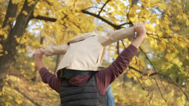 Der Junge sitzt auf den Schultern seines Vaters — Stockvideo