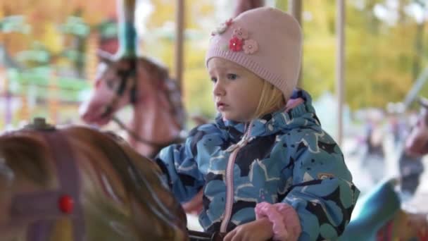 Niña montando un caballo atracción — Vídeo de stock