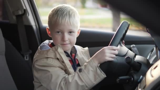 Il ragazzo sedeva sul sedile del conducente in macchina . — Video Stock