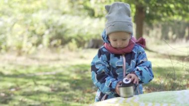Küçük bir kız kendini bir termos çay dökülen.