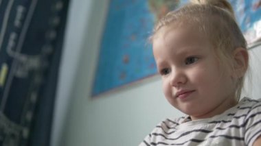 Güzel küçük bir kız kameraya bakıyor.