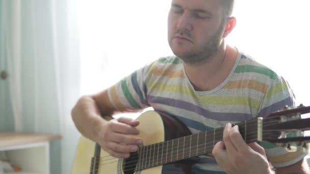 Um homem toca guitarra e canta uma canção — Vídeo de Stock