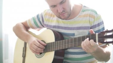 Adam bir gitar yapıyor. O tellere katlanmış ve ses kontrol