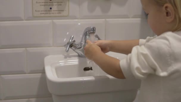 Little girl washes her hands in the baby sink. — Stock Video