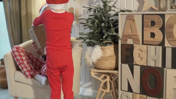 Une femme est assise sur une chaise en pyjama de Noël . — Video