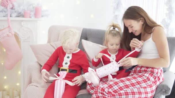 Mamá y sus hijos abren regalos de Navidad — Vídeo de stock