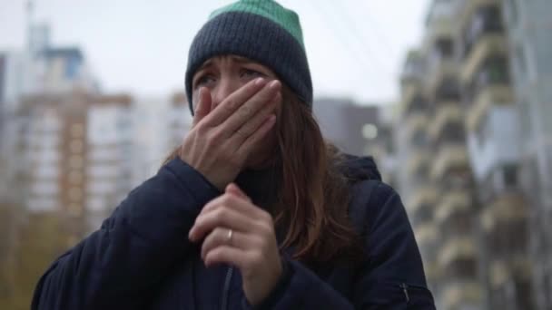 Una mujer estornuda afuera y se rasca la nariz — Vídeos de Stock