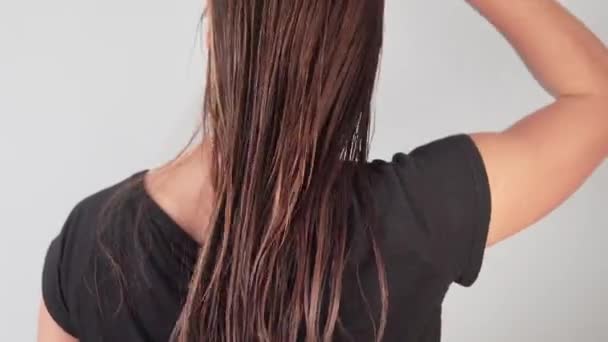 Νεαρή γυναίκα που χτενίζει τα μαλλιά βρεγμένα. — Αρχείο Βίντεο