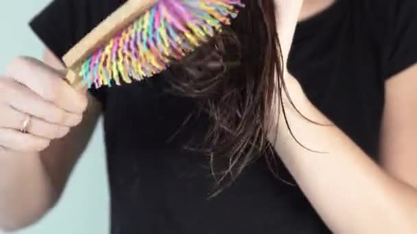 En ung kvinna kamning ändarna på håret — Stockvideo