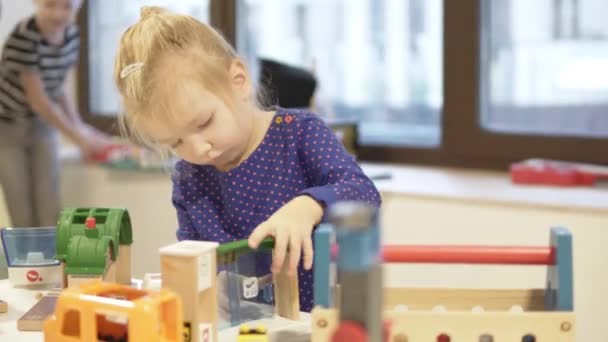 Een klein meisje en haar oudere broer spelen educatief speelgoed — Stockvideo