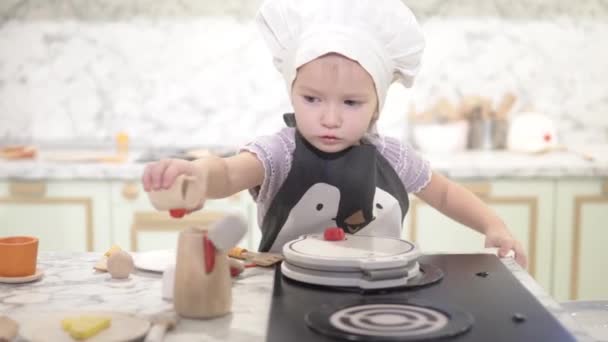 Mamá está usando un delantal con un pingüino en una niña — Vídeo de stock