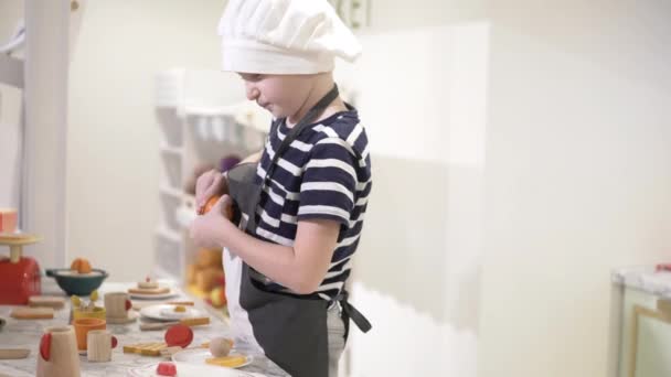 Мальчик играет на детской кухне . — стоковое видео