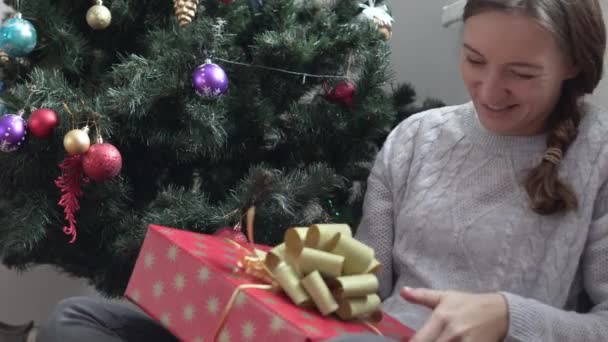 Una mujer joven está considerando su regalo de Año Nuevo — Vídeo de stock