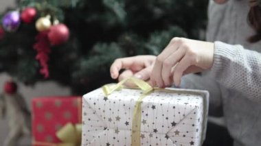 bir kadın bir paket yeni yıl hediye açar.