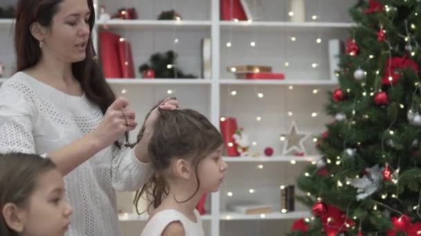 Mamma hjälper döttrar fläta långt hår för det nya året — Stockvideo