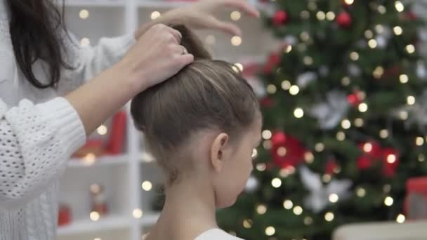 Мама заплетает волосы в хвост своей элегантной дочери — стоковое видео