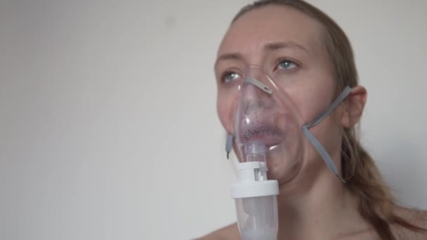 Eine Frau behandelt eine Lungenentzündung. Es macht die Inhalation mit einem Vernebler — Stockvideo