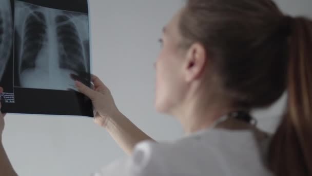 女性医師は肺の x 線を調べる — ストック動画