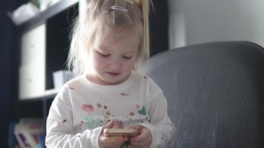 Bir cep telefonu onun elinde tutan ve ekrana bakarak güzel küçük kız