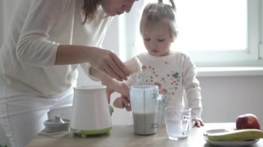 Anne ve küçük kızı bir milkshake hazırlıyor
