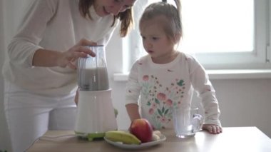 Anne ve küçük kızı bir milkshake hazırlıyor