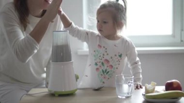 Anne ve küçük kızı bir milkshake hazırlıyor