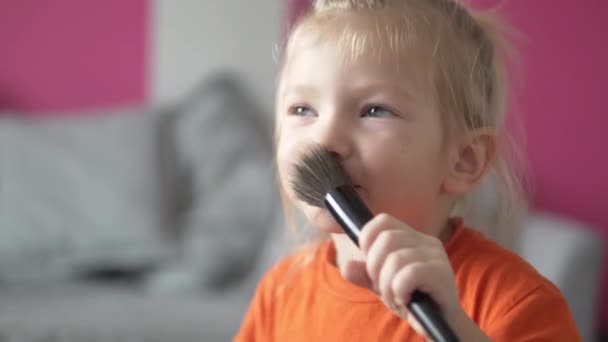 Чарівна маленька дівчинка пудрить щоки з рожевим — стокове відео