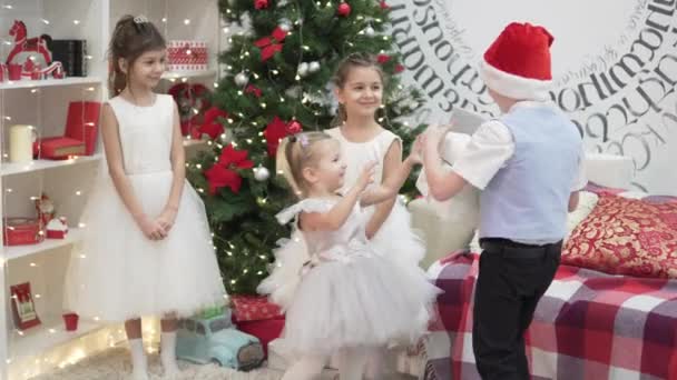 Stoją trzy smart małe dziewczynki w białych sukniach ubrane choinki — Wideo stockowe