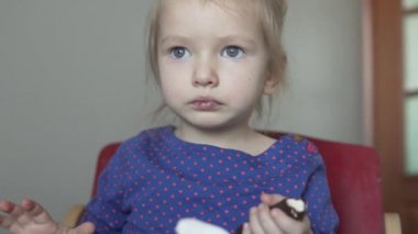 Tatlı bir pasta yiyen küçük kız