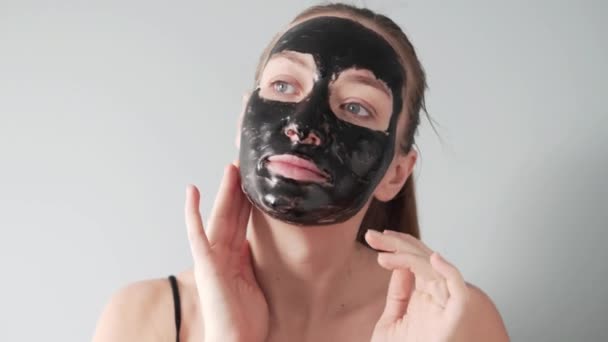 Μια όμορφη νεαρή γυναίκα βάλει μια ταινία μαύρη μάσκα στο πρόσωπό της — Αρχείο Βίντεο