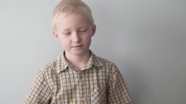 Um menino loiro puxa para fora um buquê de rosas rosa por trás — Vídeo de Stock