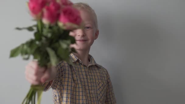 Funny boy blond stretches a bouquet of small roses — Stock Video