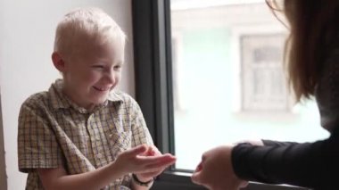 Sarışın yakışıklı bir çocuk ve onun anne bayanlar oynuyor