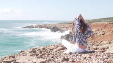Bir kadın kamera geri ile oturur ve denize bakmak