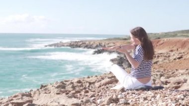 Turist bir kaya üzerinde güzel bir yerde jimnastik yapıyor deniz
